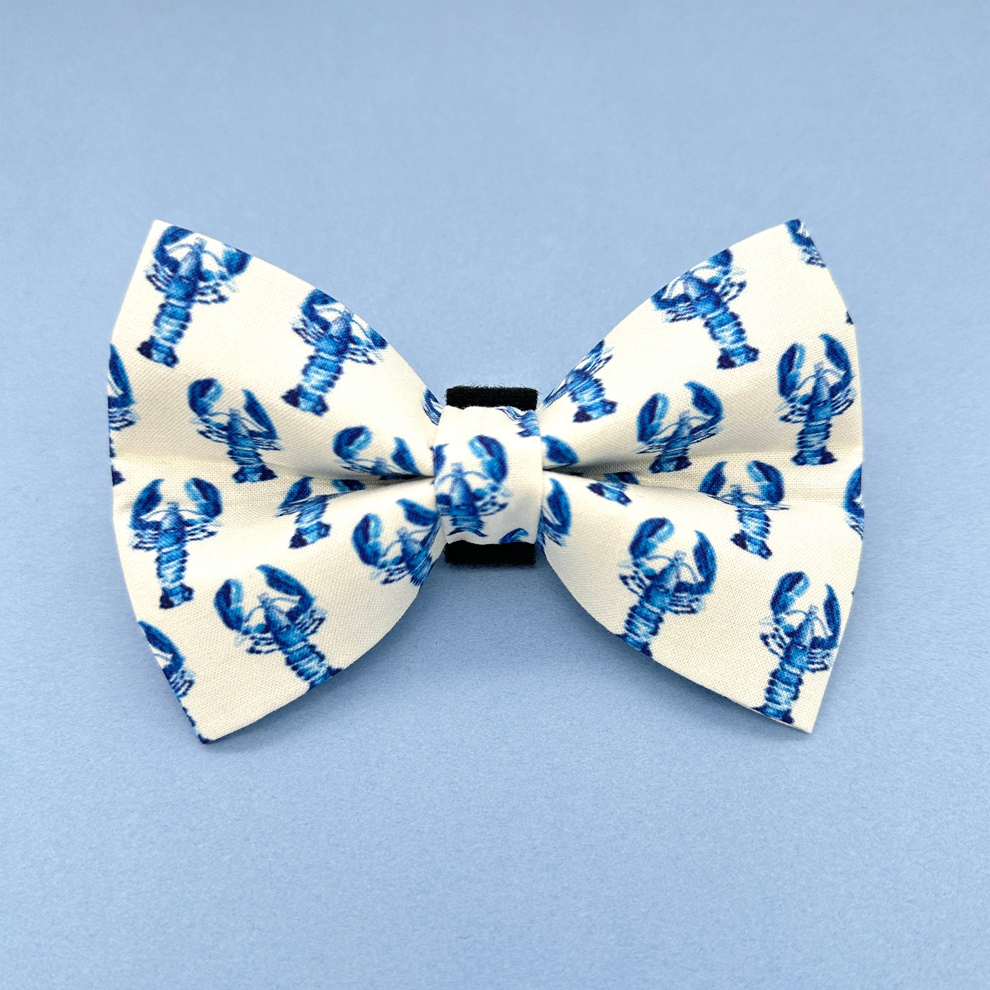 White bow tie with blue lobster pattern on a light blue background