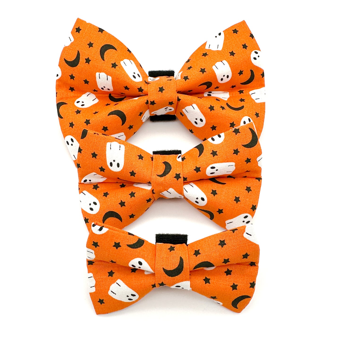 Halloween-themed bow tie with ghost and moon pattern on orange background