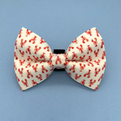 White bow tie with red lobster pattern on a blue background